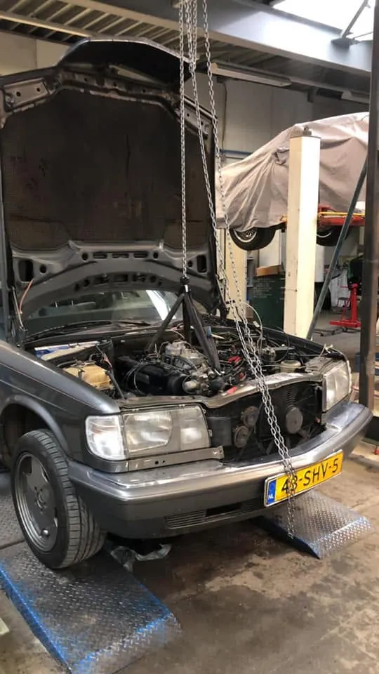 W124 op de brug in de werkplaats met de motorkap open